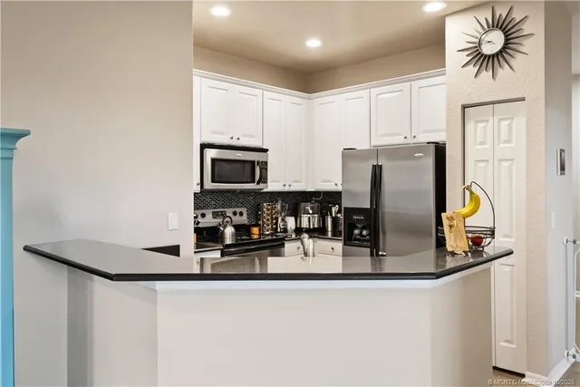 a kitchen with a refrigerator a stove and a microwave with wooden floor