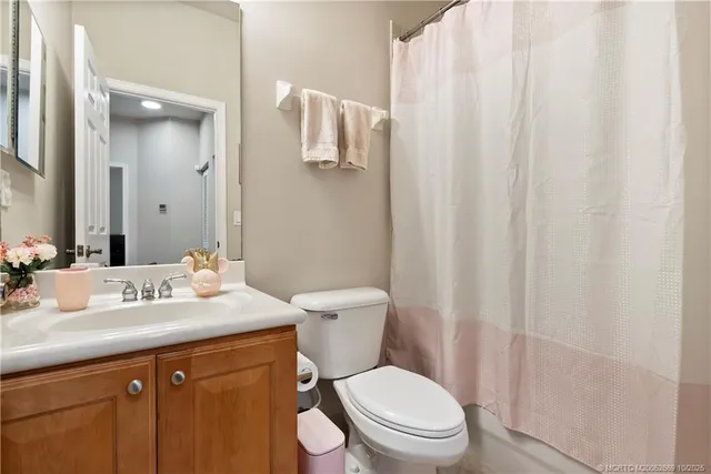 a bathroom with a sink a toilet and shower curtain