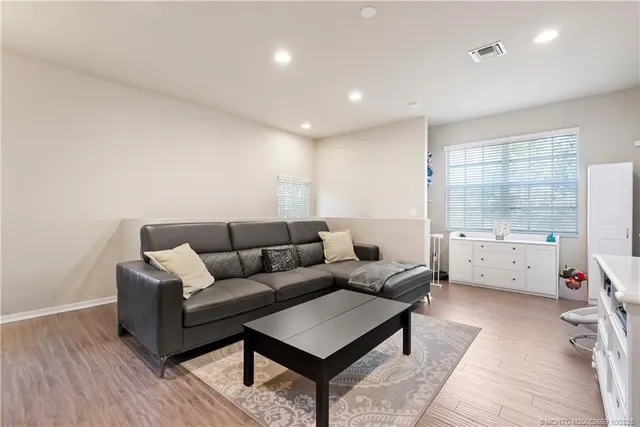 a living room with furniture a flat screen tv and a window