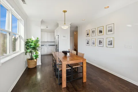 a dining room with furniture potted plants and wooden floor