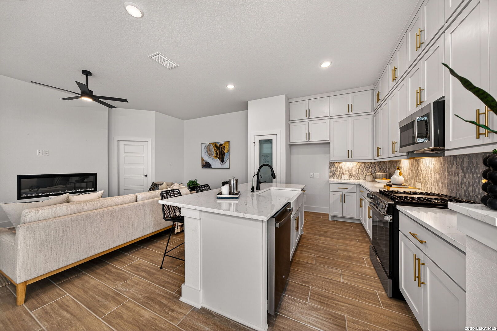 20675 Huebner Road, Unit 527 San Antonio, TX 78258 - Photo 11 of 33 a kitchen with stainless steel appliances a stove top oven a sink a refrigerator white cabinets and wooden floor