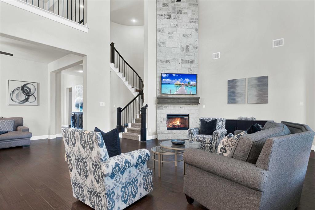 616 Windy Ridge Lane Rockwall, TX 75087 - Photo 2 of 25 a living room with furniture a fireplace and a flat screen tv