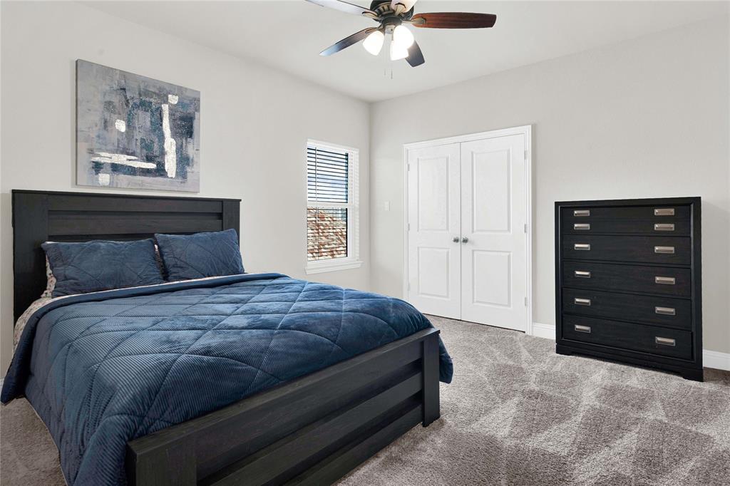 616 Windy Ridge Lane Rockwall, TX 75087 - Photo 20 of 25 a bedroom with a bed and a chandelier