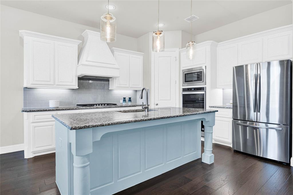 616 Windy Ridge Lane Rockwall, TX 75087 - Photo 3 of 25 a kitchen with stainless steel appliances granite countertop a sink a stove a refrigerator and island with wooden floor