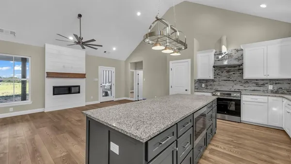 a kitchen with kitchen island white cabinets and refrigerator