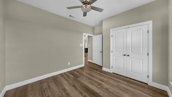 a view of a big room with wooden floor and windows