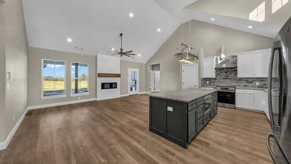 a large kitchen with stainless steel appliances kitchen island a sink dishwasher a stove and a refrigerator