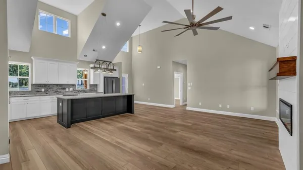 a view of an empty room with a fireplace and a window
