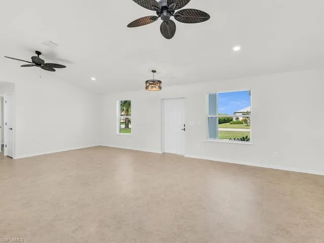 an empty room with a window and a ceiling fan