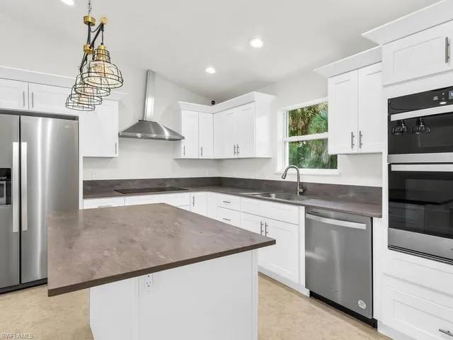 a kitchen with stainless steel appliances a sink stove and refrigerator