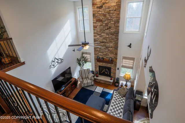 a living room with furniture a flat screen tv and a floor to ceiling window