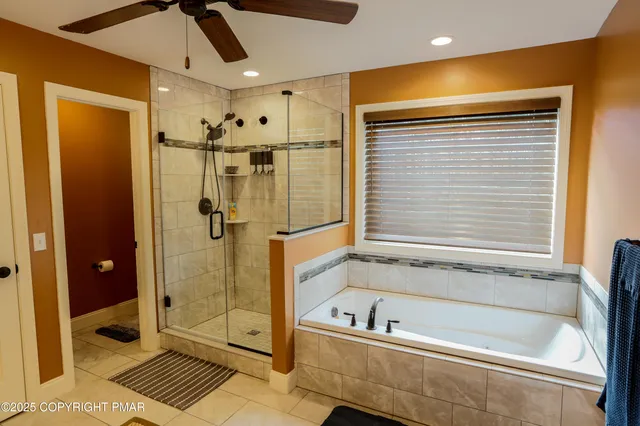 a bedroom with a bed and ceiling fan