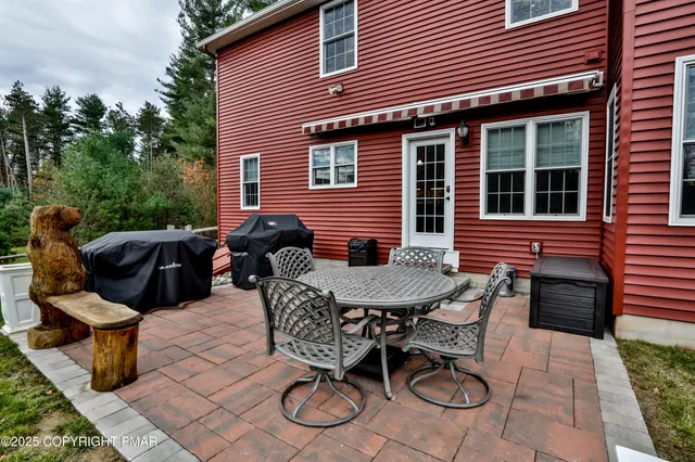 a view of a brick house with a yard chairs and a table