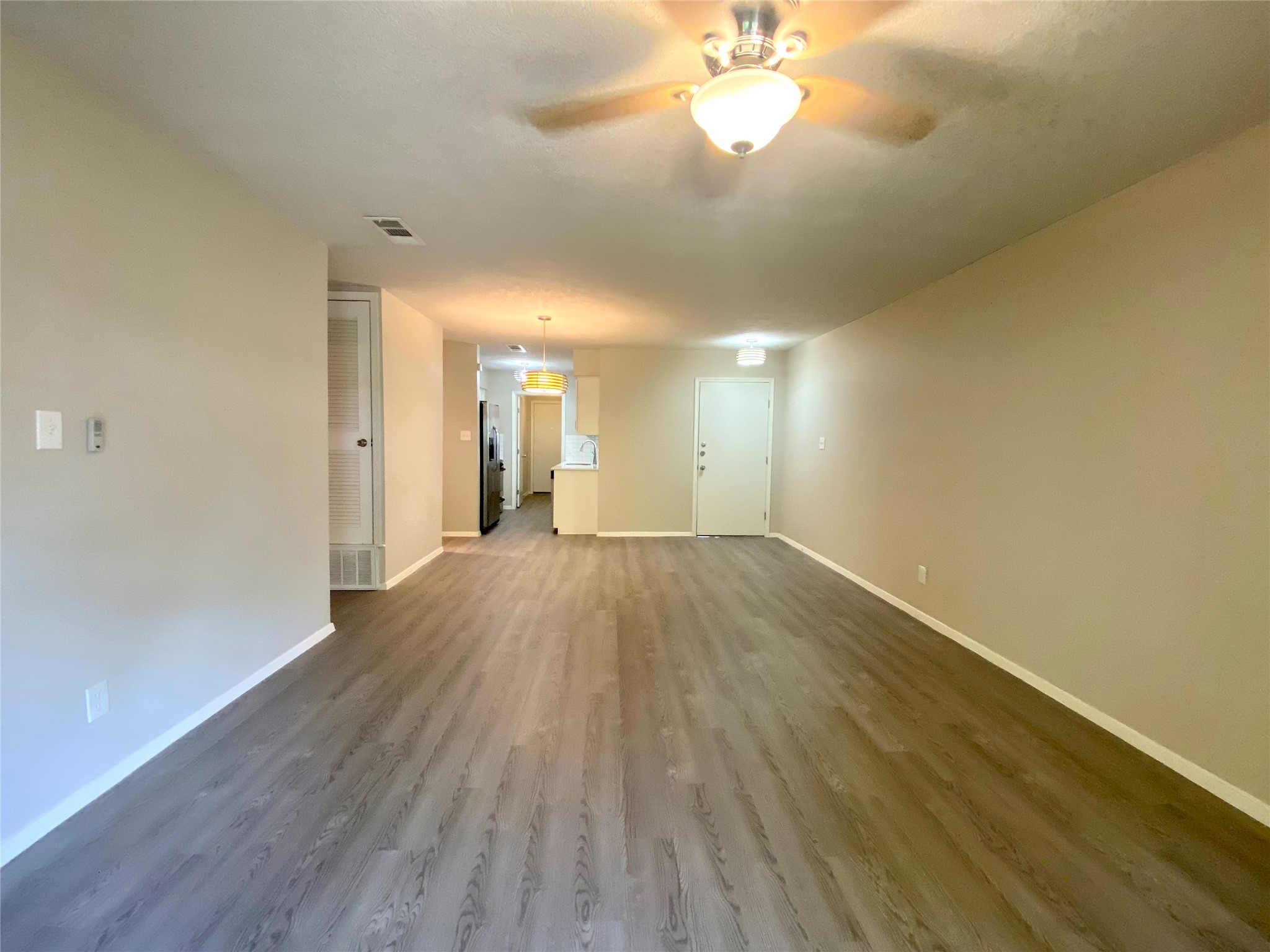 6400 Brookside Drive Austin, TX 78723 - Photo 12 of 26 Unfurnished living room featuring a ceiling fan and dark wood-style flooring