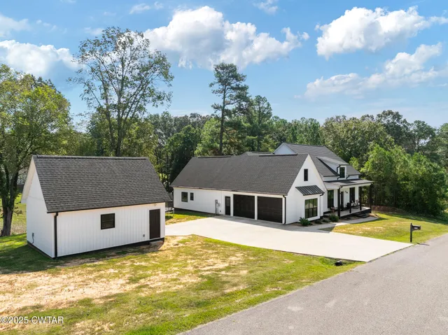 a house view with a swimming pool and trees in the background
