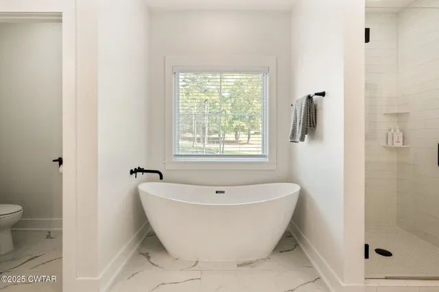 a white bath tub sitting next to a white toilet