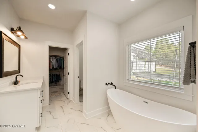a spacious bathroom with sink shower and bathtub