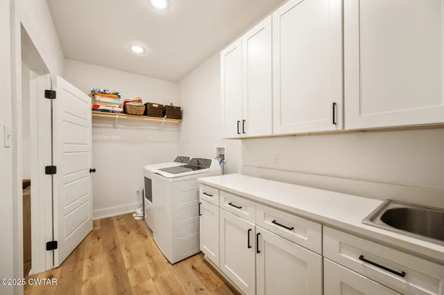 a view of a storage utility room with cabinets washer and dryer