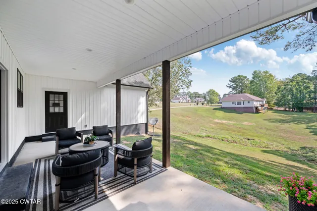 a living room with furniture and a floor to ceiling window