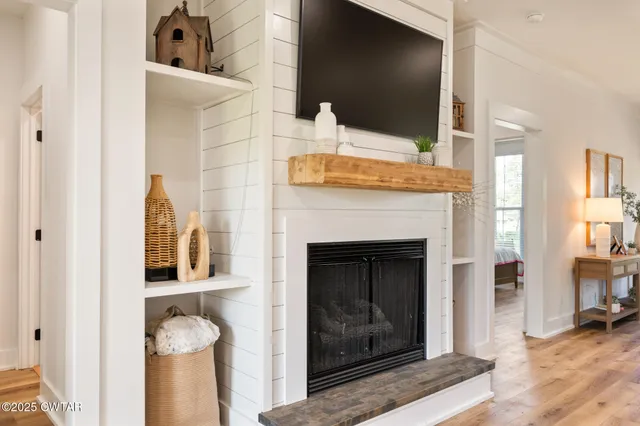 a living room with a fireplace and a flat screen tv