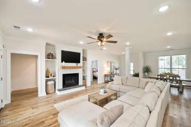 a living room with furniture a fireplace and a flat screen tv