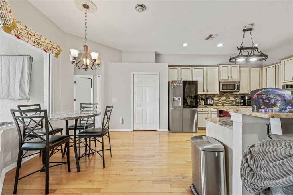 22623 Cliffside Way Land O' Lakes, FL 34639 - Photo 13 of 49 a open kitchen with stainless steel appliances granite countertop a dining table chairs refrigerator and cabinets