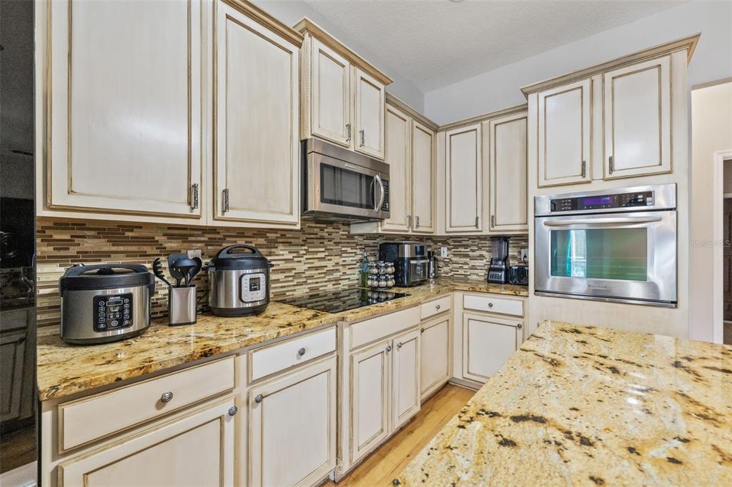 22623 Cliffside Way Land O' Lakes, FL 34639 - Photo 20 of 49 a kitchen with granite countertop white cabinets and stainless steel appliances