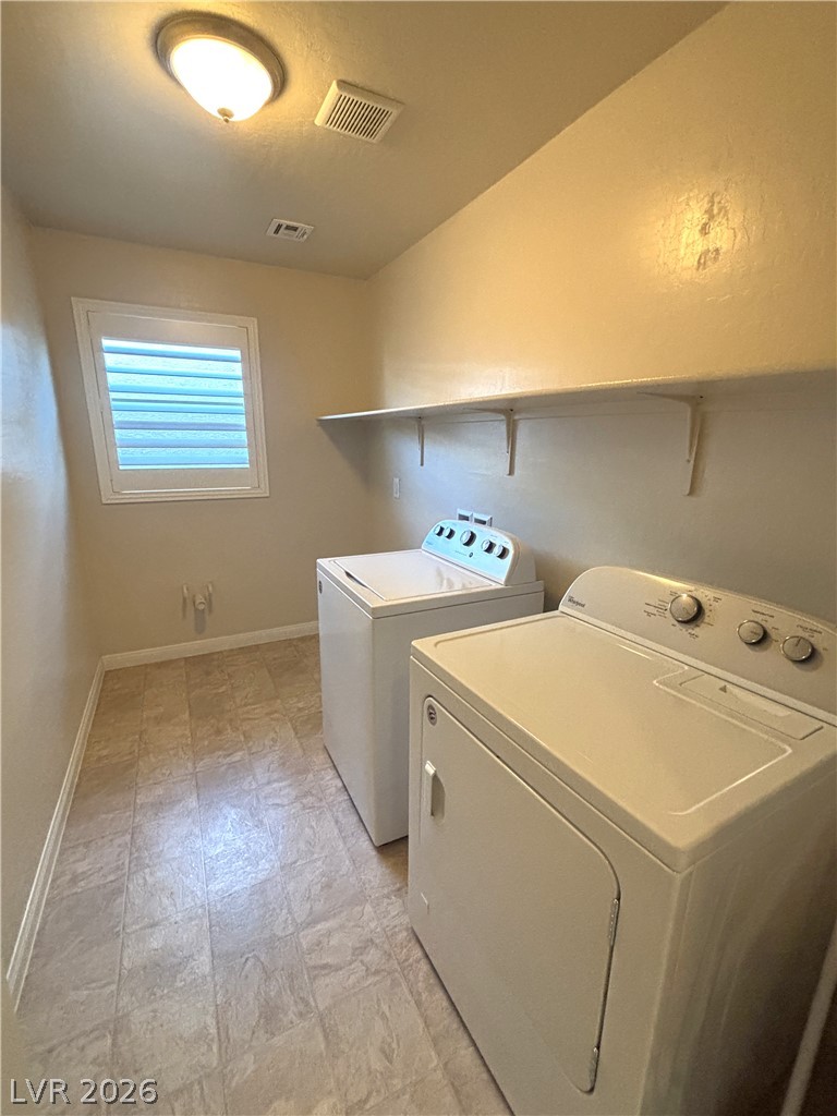 121 Elm Reed Avenue Las Vegas, NV 89113 - Photo 21 of 30 Functional laundry space featuring durable tile flooring and convenient shelving for storage.