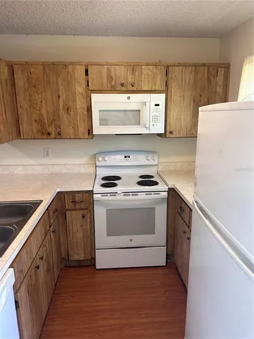 a kitchen with a cabinets and white appliances