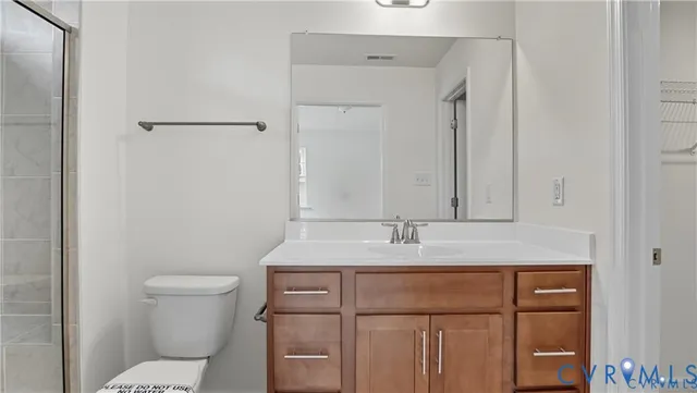 a bathroom with a granite countertop sink toilet and mirror
