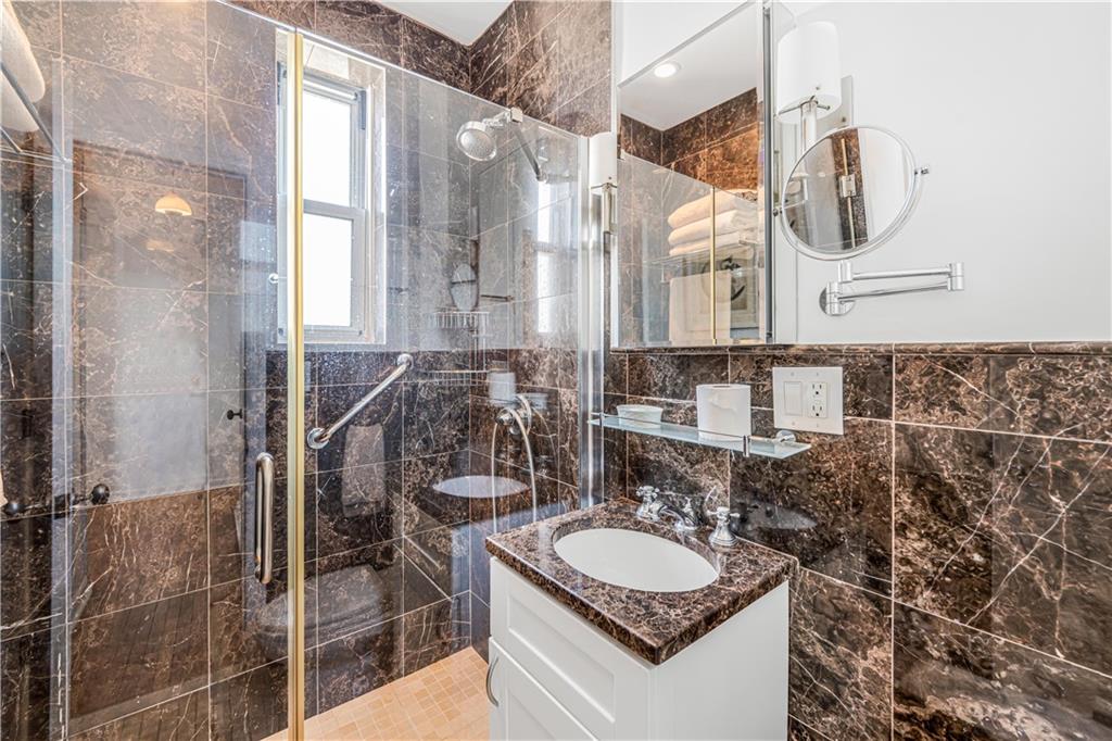 286 Corbin Place, Unit 5E Brooklyn, NY 11235 - Photo 16 of 35 a bathroom with a sink and a mirror