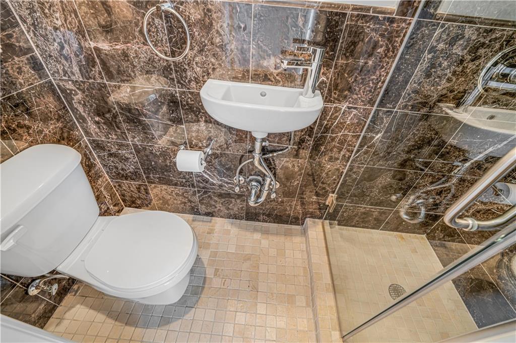 286 Corbin Place, Unit 5E Brooklyn, NY 11235 - Photo 27 of 35 a bathroom with a toilet and a sink