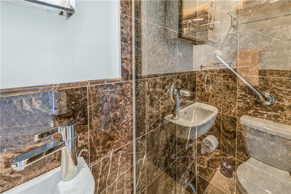 286 Corbin Place, Unit 5E Brooklyn, NY 11235 - Photo 28 of 35 a bathroom with a sink and mirror