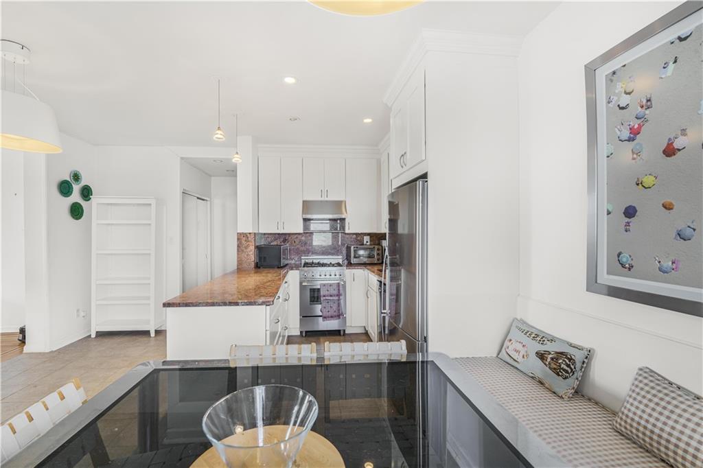 286 Corbin Place, Unit 5E Brooklyn, NY 11235 - Photo 10 of 35 a kitchen with stainless steel appliances granite countertop a refrigerator and a stove top oven