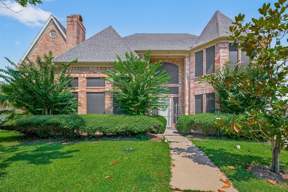 a front view of a house with a yard and trees