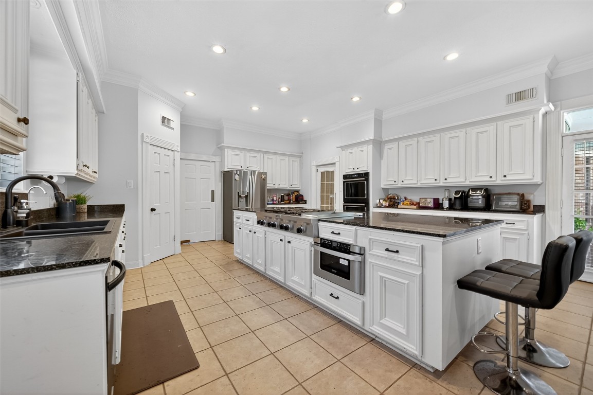 17318 Rothko Lane Spring, TX 77379 - Photo 13 of 46 a kitchen with stainless steel appliances kitchen island granite countertop a sink and cabinets