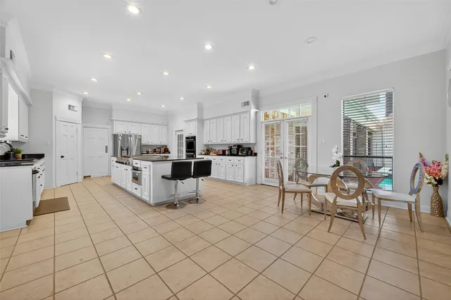 a large kitchen with white cabinets and stainless steel appliances
