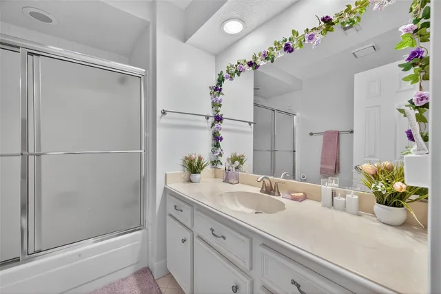 a bathroom with a shower sink and a mirror