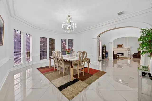 a living room with furniture a chandelier and a dining table