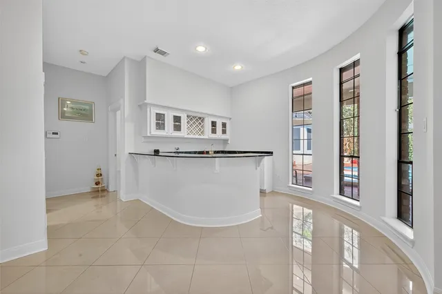 a view of kitchen with granite countertop cabinets and window