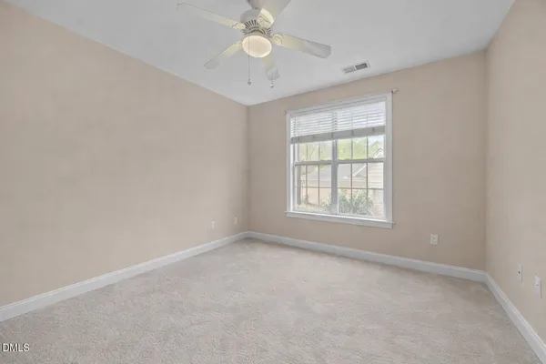 an empty room with a window and a fan