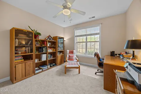 a room with furniture a bookshelf and a window