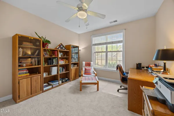 a room with furniture a bookshelf and a window