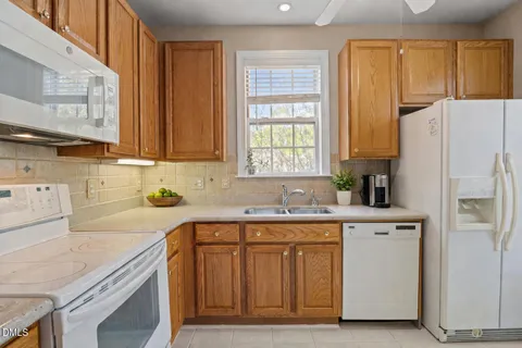 a kitchen with a sink a refrigerator and window