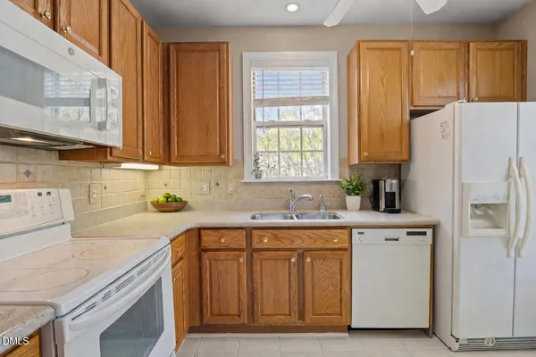 a kitchen with a sink a refrigerator and window
