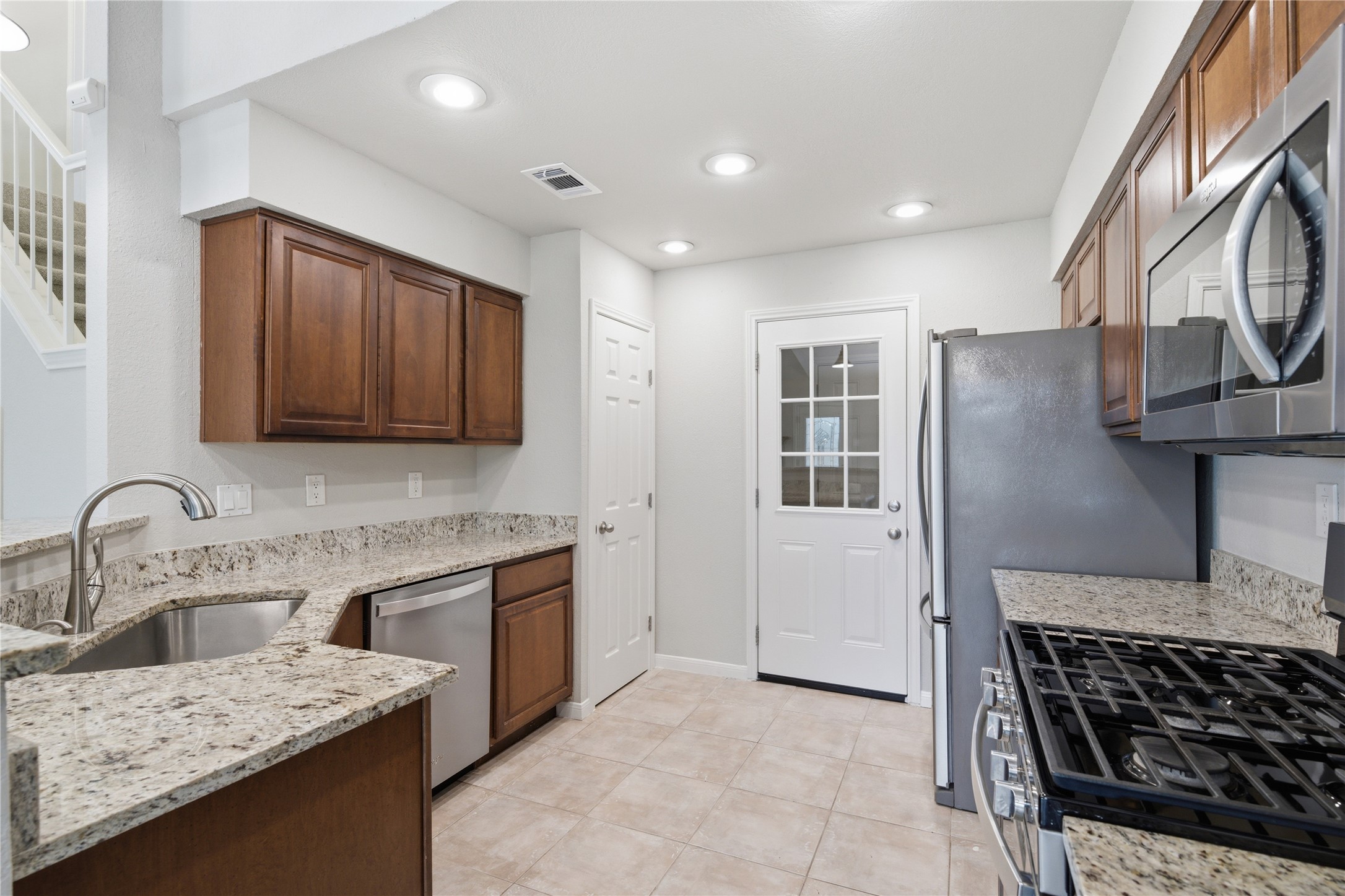 1317 Mimosa Pass Cedar Park, TX 78613 - Photo 19 of 20 a kitchen with stainless steel appliances granite countertop a sink stove and refrigerator