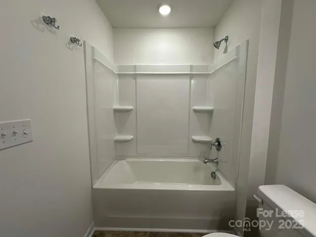a bathroom with a bathtub a toilet and a shower