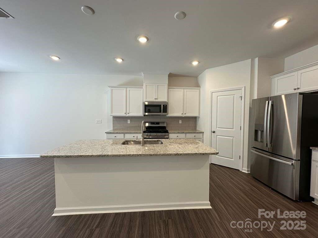 3512 Nimbell Road Monroe, NC 28110 - Photo 6 of 18 a kitchen with stainless steel appliances granite countertop a refrigerator a sink dishwasher a stove and white countertops with wooden floor