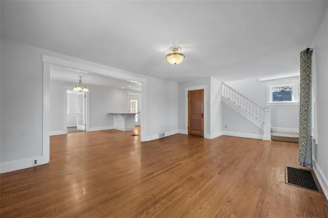 a view of empty room with wooden floor and window