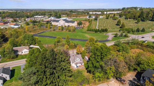 an aerial view of residential houses with outdoor space and trees